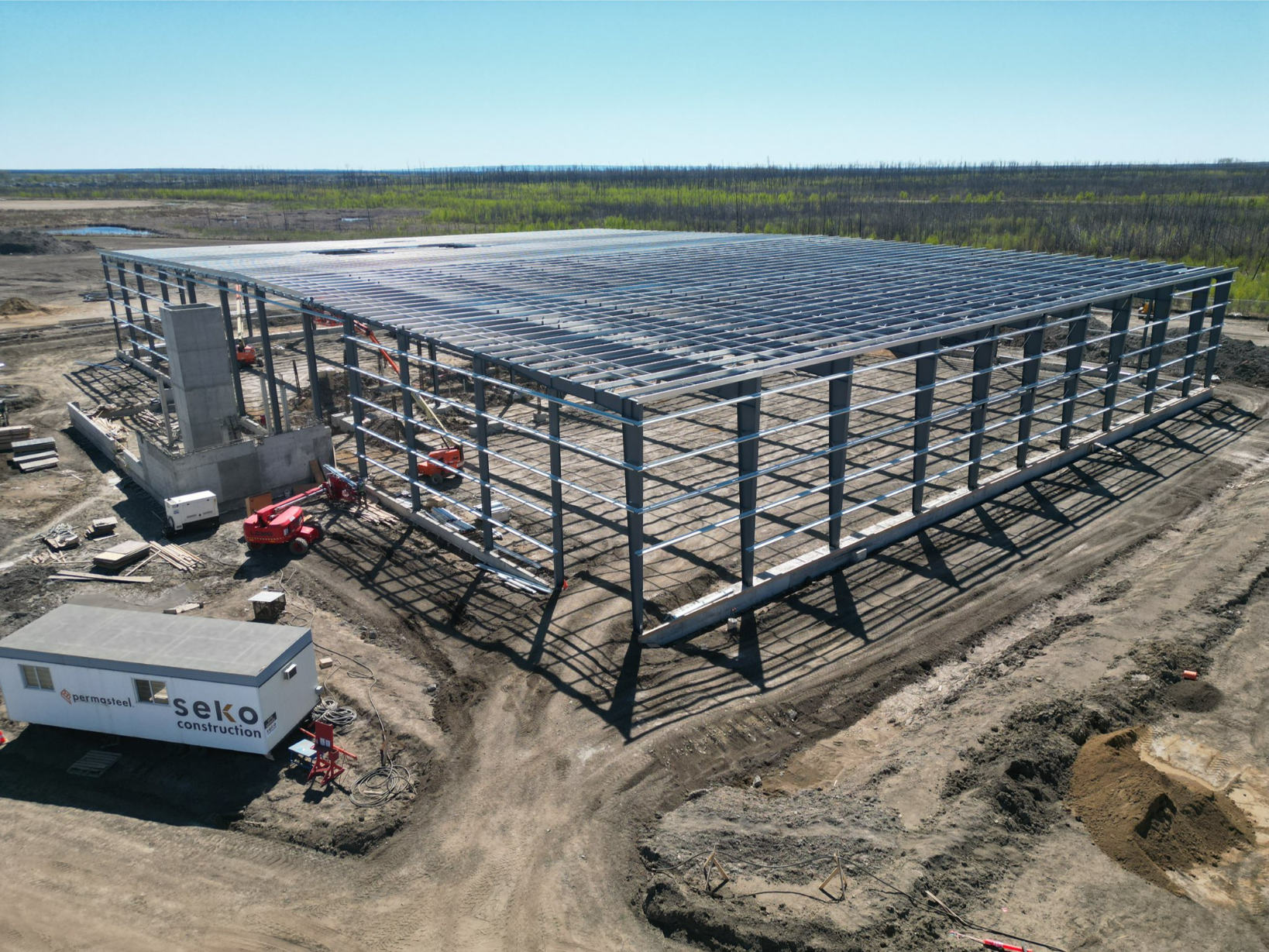 Service area construction features a metal framework with solar panels in a barren landscape